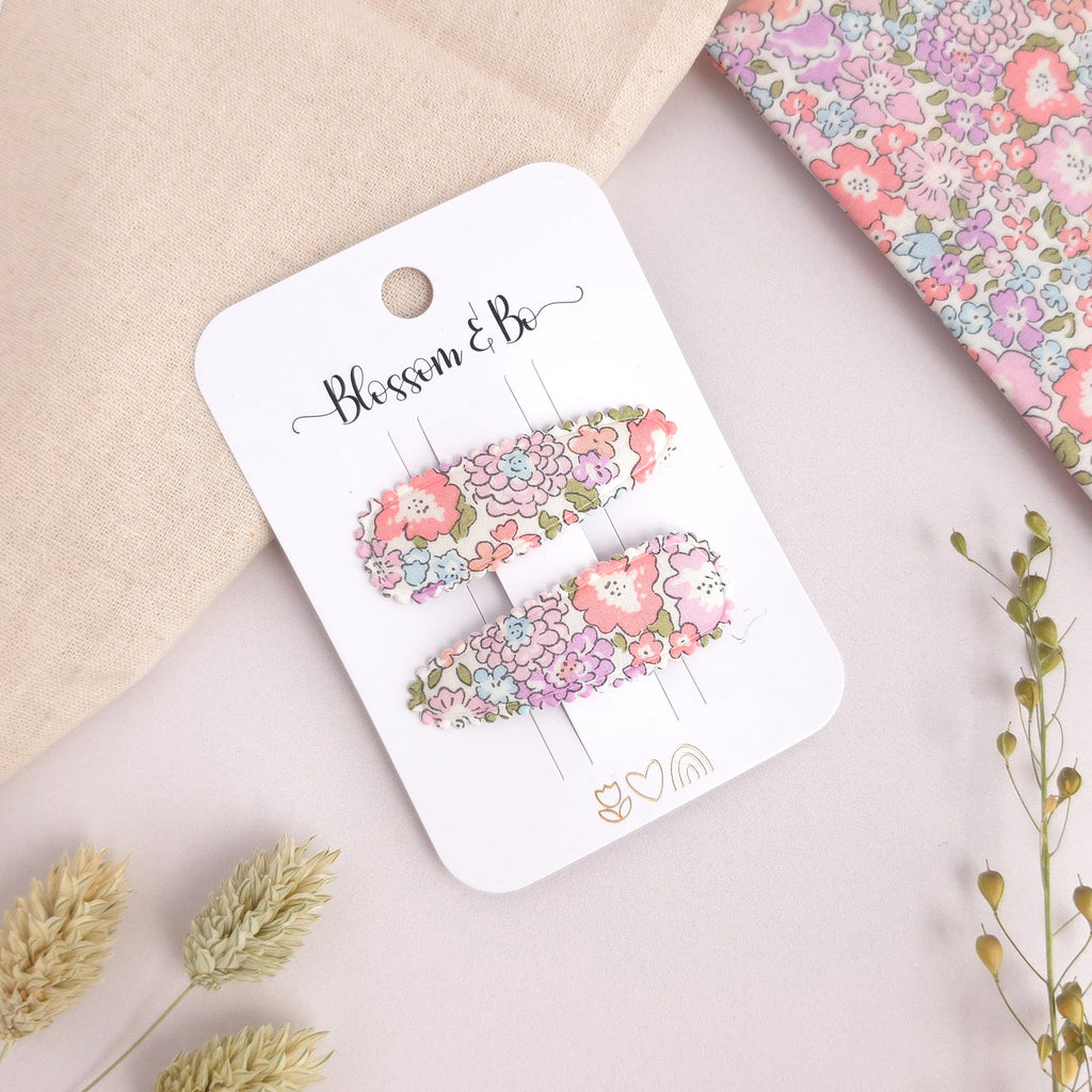 Floral hair clips on a 'Blossom & Co' branded card with a floral background.
