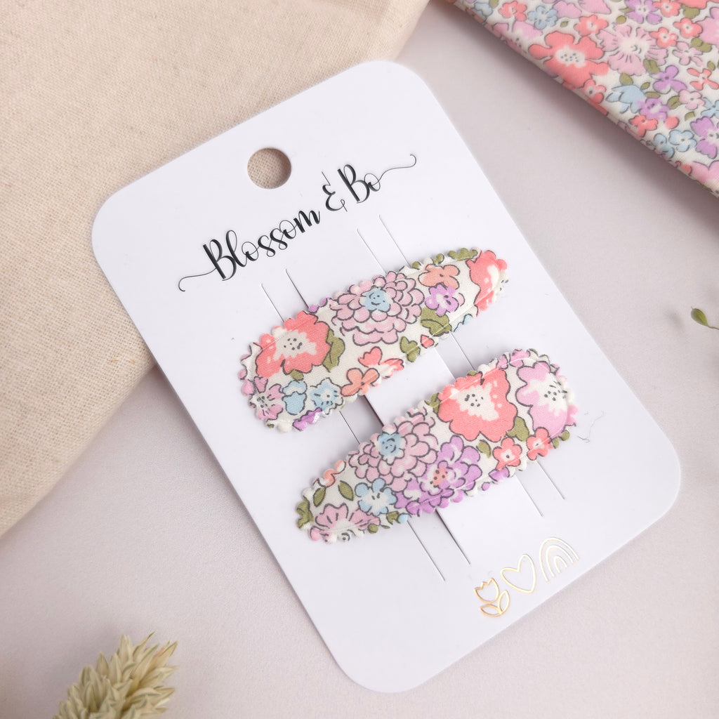 Liberty print snap clips for toddlers on a white branded display card