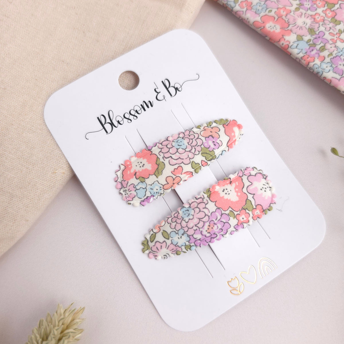 Liberty print snap clips for toddlers on a white branded display card
