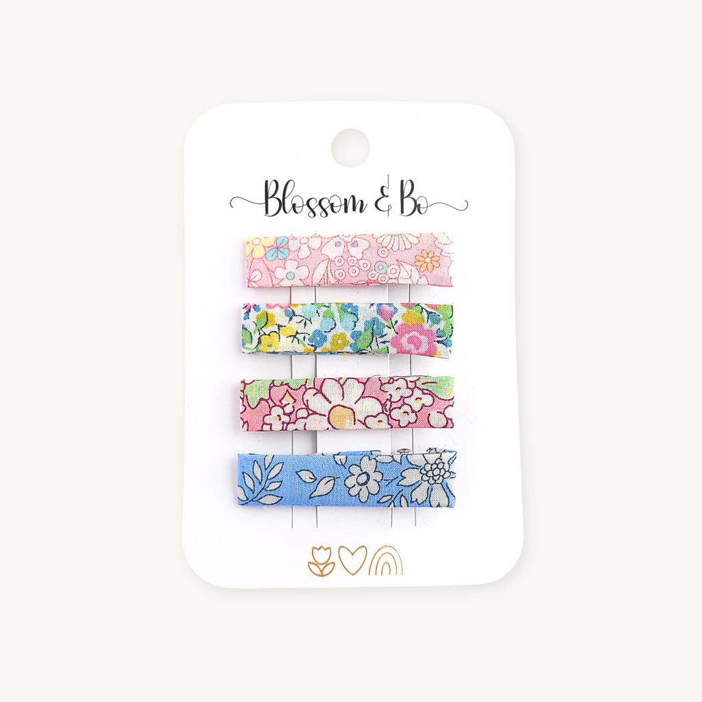Set of four Liberty floral alligator clips in pink and blue prints on a Blossom & Bo display card
