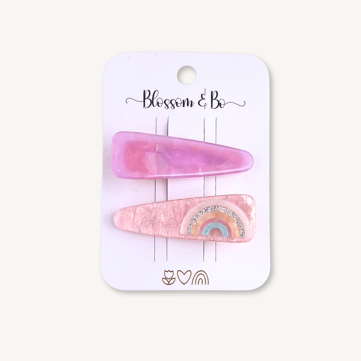 Set of two pink acrylic hair clips featuring a marbled pink clip and a rainbow design on a Blossom & Bo display card.