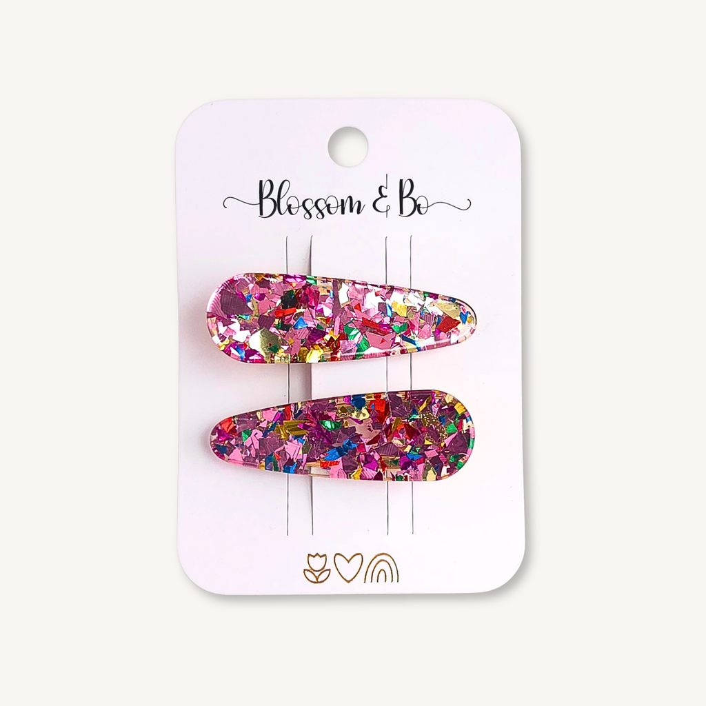 Pair of pink confetti acrylic hair clips with colourful glitter on a Blossom & Bo display card.
