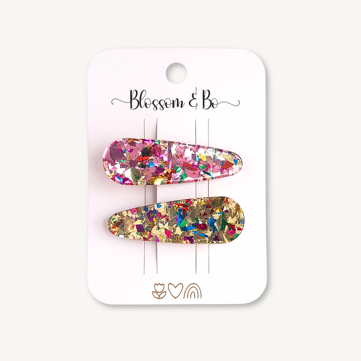 Pair of pink and gold confetti acrylic hair clips with multicoloured glitter on a Blosom & Bo display card.