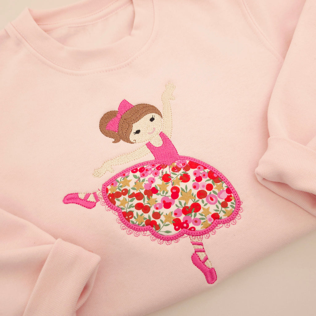 Close up of an embroidered ballerina with a pink floral Liberty of London fabric applique skirt