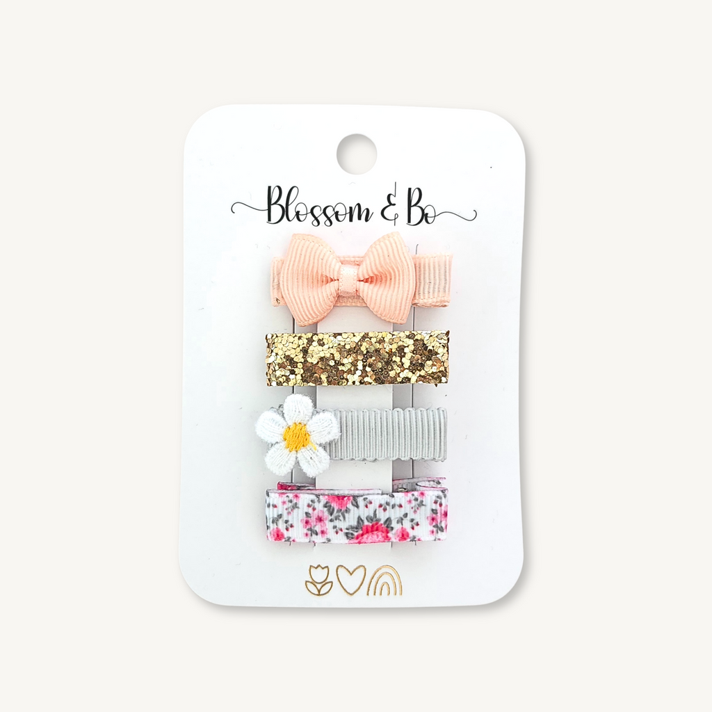 Set of four mini hair clips for girls with pink bow, glitter, daisy and floral design