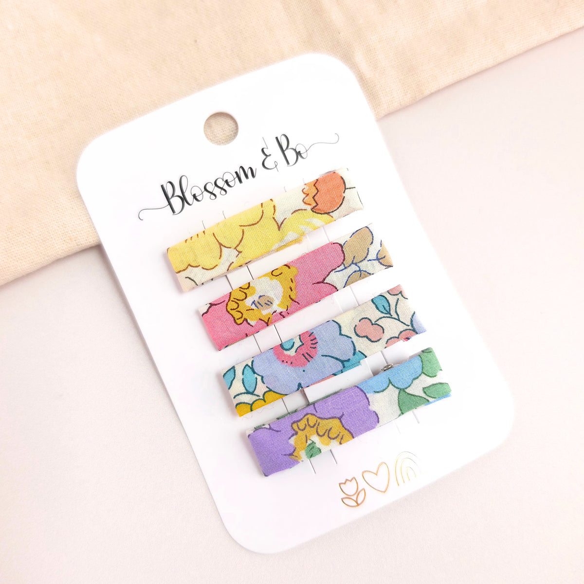 Set of colorful hair clips on a 'Blossom & Co' branded card.