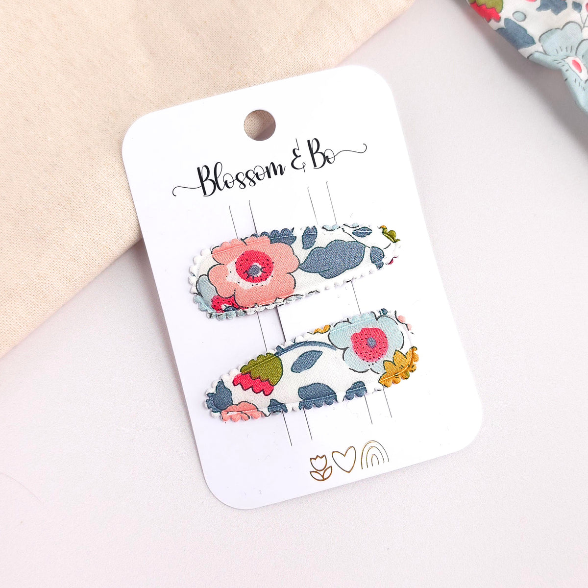 Floral hair clips on a 'Blossom & Co' branded card with a soft background