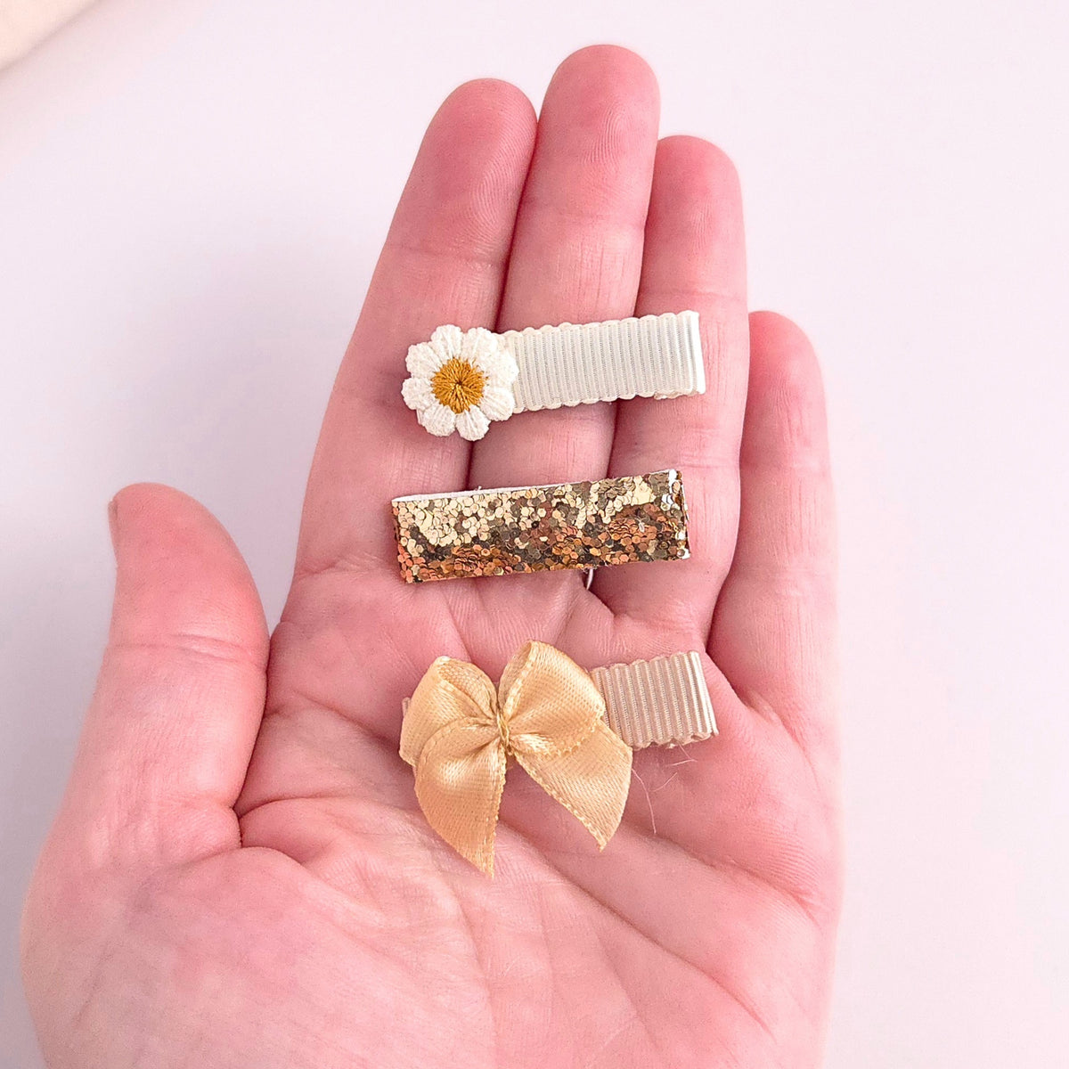 Neutral baby and toddler mini hair clip set with embroidered daisy, gold glitter alligator clip and beige satin bow.
