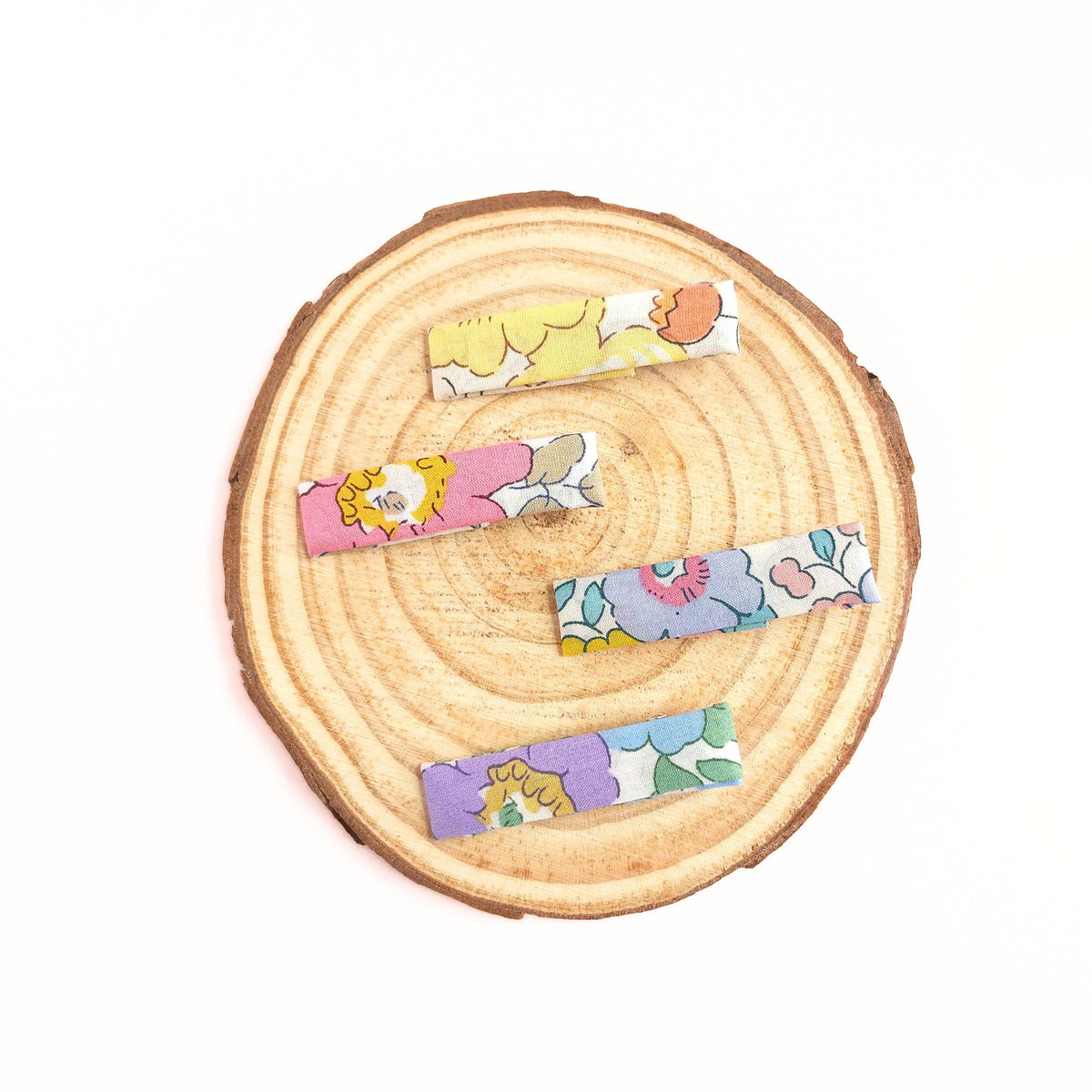 Set of colorful floral hair clips on a wooden surface