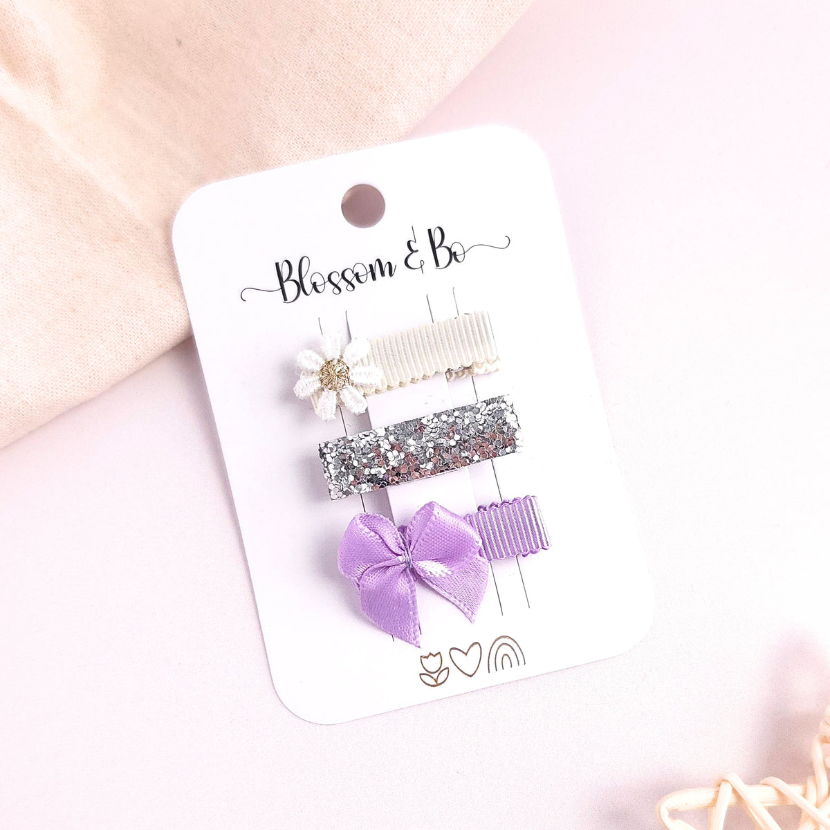 Lilac baby and toddler mini hair clip set with white embroidered daisy, silver glitter alligator clip and lilac satin bow on a Blossom & Bo display card.
