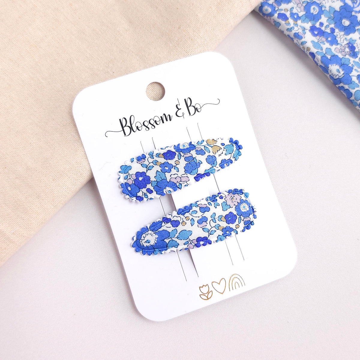 Pair of blue Liberty floral fabric snap clips on Blossom & Bo display card