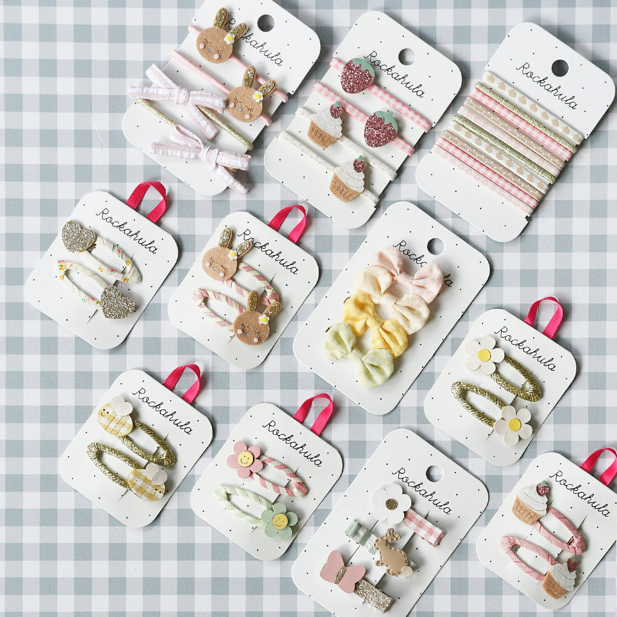 Collection of hair accessories on display cards with 'Rockahula' branding on a checkered background.