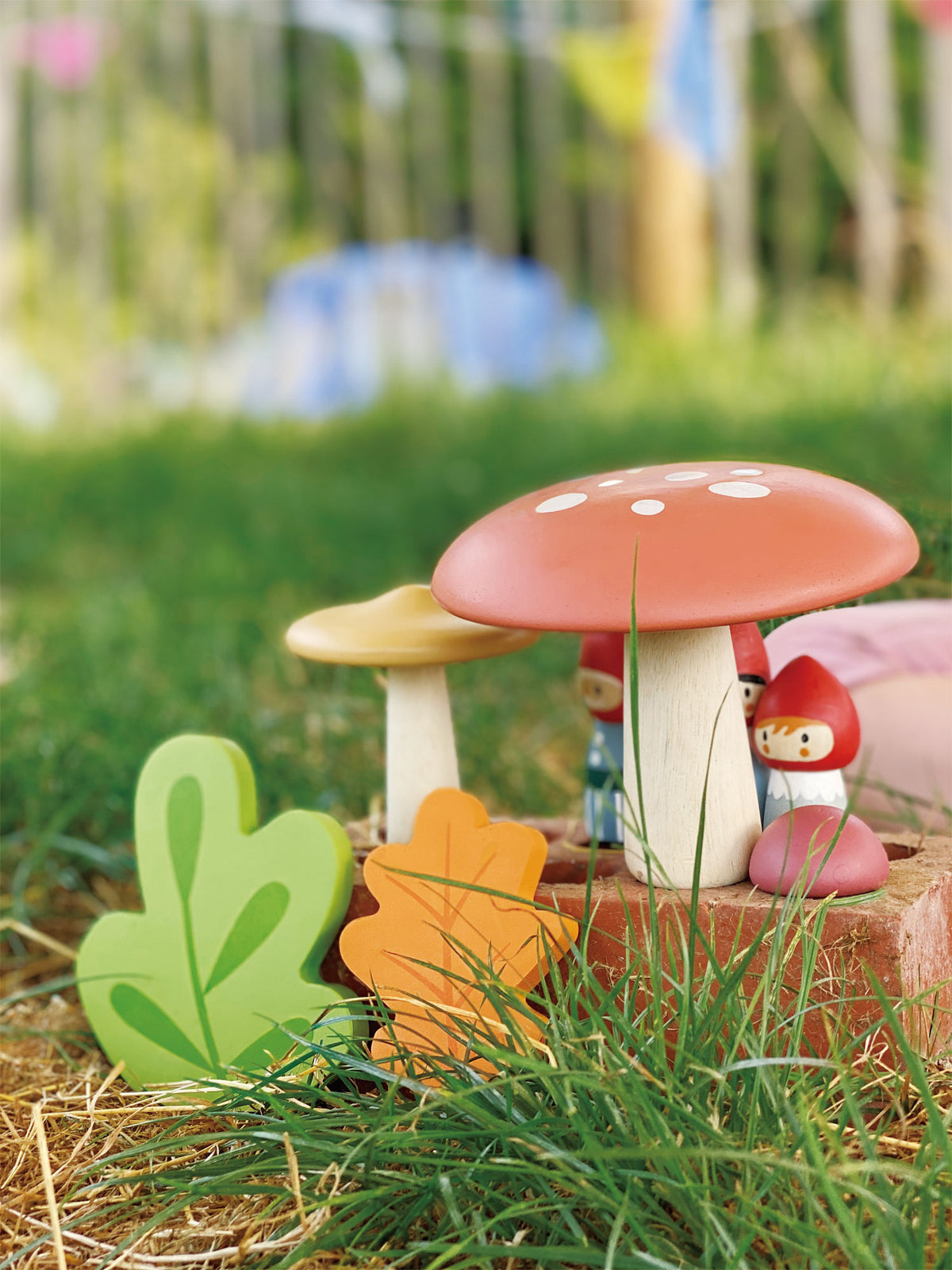 Miniature garden scene with colorful mushrooms and a gnome on grass