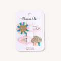 Set of two fabric covered snap hair clips featuring a glitter sun and rainbow cloud on a Blossom & Bo display card.