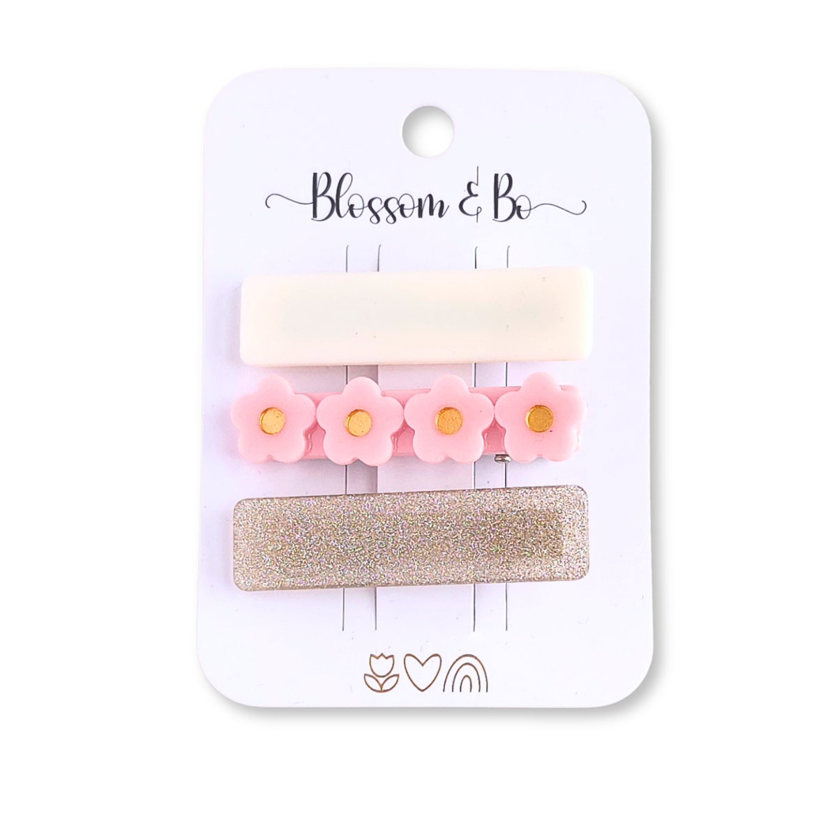 Set of three acrylic hair clips featuring a cream clip, pink daisy clip and gold glitter clip on a Blossom & Bo display card.