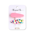 A set of two hair clips on a white display card. The top clip is solid pastel pink, and the bottom clip is white with multicolor confetti speckles in pink, blue, yellow, and black.