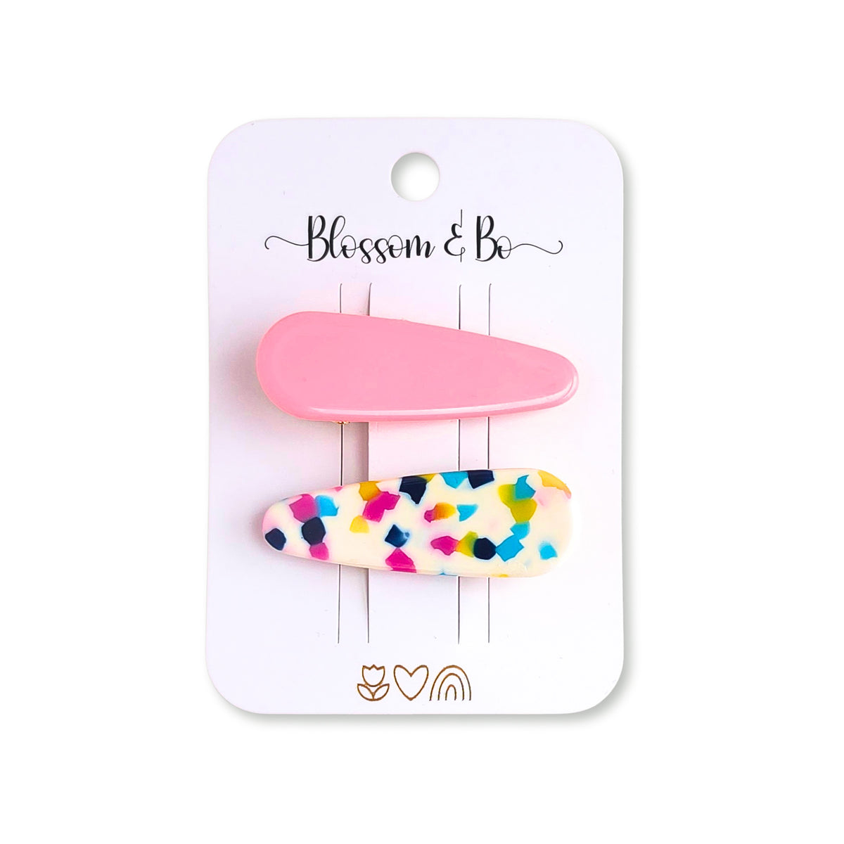 A set of two hair clips on a white display card. The top clip is solid pastel pink, and the bottom clip is white with multicolor confetti speckles in pink, blue, yellow, and black.