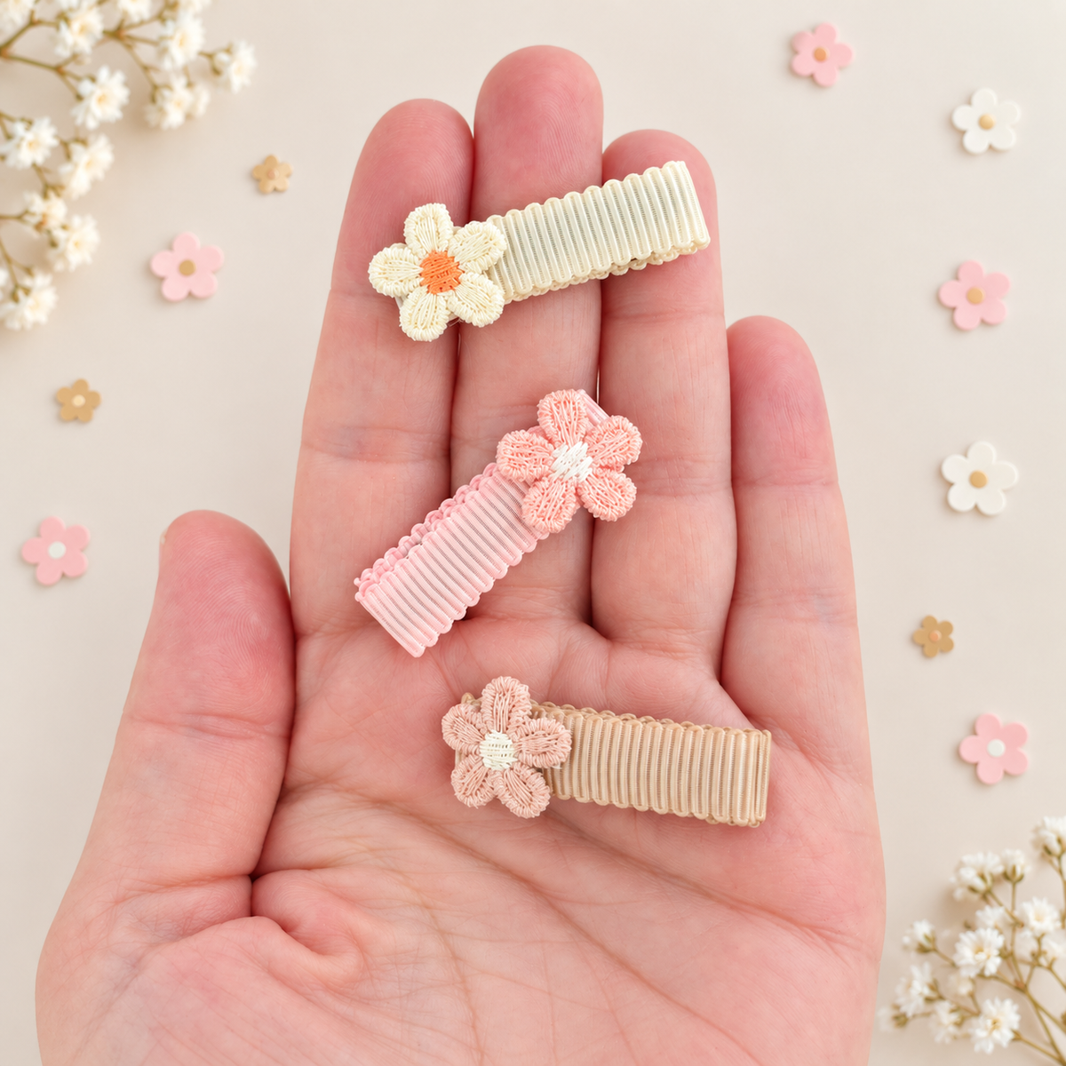 Mini flower hair clips shown in hand, with neutral ribbon lined clips